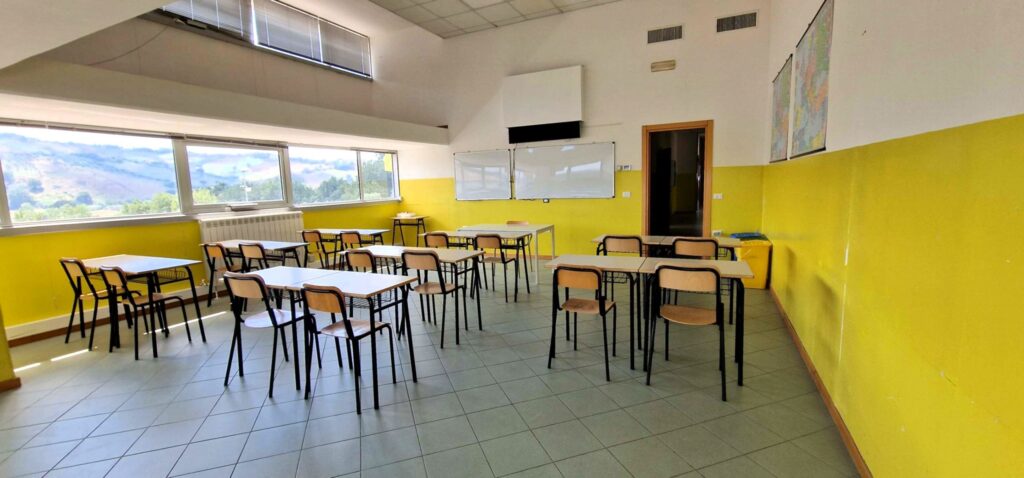 Aula degli Istituti Cameli con tavoli per lo studio, librerie e lavagna.