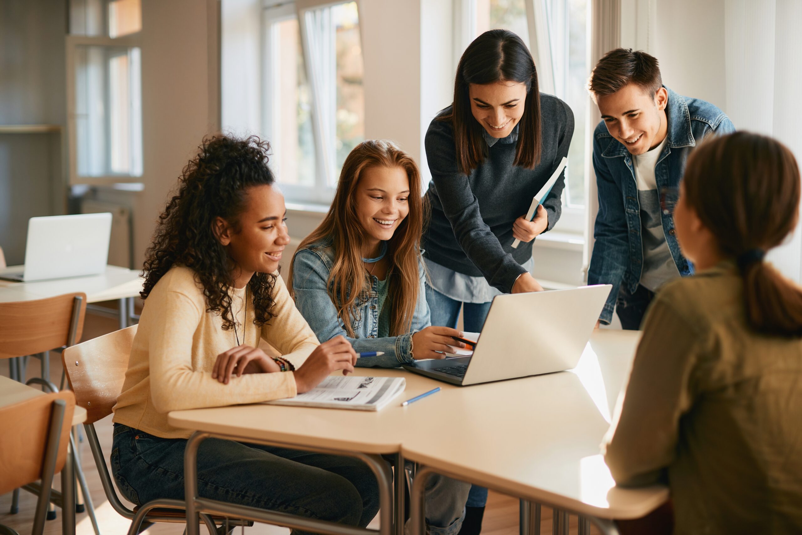 Insegnante e studenti lavorano insieme intorno a un tavolo